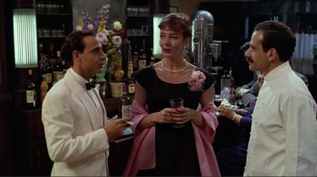 Movie still from “Big Night” (1996), directed by Stanley Tucci – A man and a woman are standing in a bar; Medium shot, Over the shoulder angle