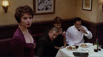 Movie still from “Big Night” (1996), directed by Stanley Tucci – A group of people sitting around a table; Medium shot, Over the shoulder angle