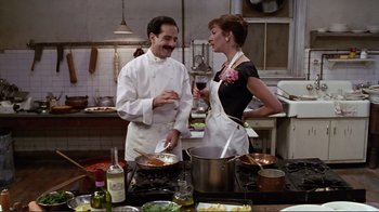 Movie still from “Big Night” (1996), directed by Stanley Tucci – A man and a woman in the kitchen with wine; Medium shot, Low angle