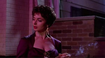 Movie still from “Big Night” (1996), directed by Stanley Tucci – A woman smoking a cigarette while wearing a purple dress; Close Up shot, Low angle