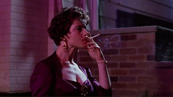 Movie still from “Big Night” (1996), directed by Stanley Tucci – A woman smoking a cigarette while wearing a purple dress; Close Up shot, Low angle