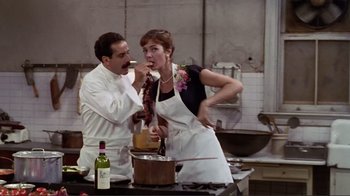 Movie still from “Big Night” (1996), directed by Stanley Tucci – A man and a woman in the kitchen preparing food; Medium shot, Over the shoulder angle