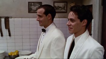 Movie still from “Big Night” (1996), directed by Stanley Tucci – A couple of men standing next to each other in a room; Medium shot, Low angle