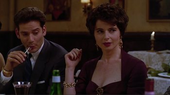 Movie still from “Big Night” (1996), directed by Stanley Tucci – A woman in a purple dress sitting in front of a man; Close Up shot, Over the shoulder angle