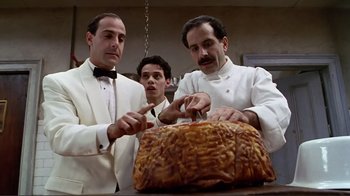 A group of men standing next to each other in front of a cake
