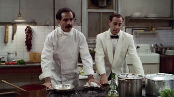 Movie still from “Big Night” (1996), directed by Stanley Tucci – Two men in white suits are cooking in a kitchen; Medium shot, Low angle