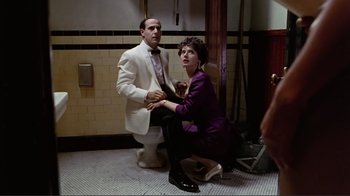 Movie still from “Big Night” (1996), directed by Stanley Tucci – A woman kneeling down next to a man on a toilet; Medium shot, Low angle