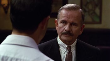 Movie still from “Big Night” (1996), directed by Stanley Tucci – An older man wearing a suit and tie talking to a younger man; Close Up shot, Over the shoulder angle