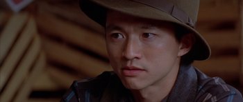 Movie still from “Big Trouble in Little China” (1986), directed by John Carpenter – A person wearing a hat; Close Up shot, Over the shoulder angle