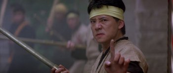 A man with a yellow head band is holding a knife