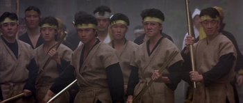 Movie still from “Big Trouble in Little China” (1986), directed by John Carpenter – A group of men in traditional japanese garb holding weapons; Medium shot, Low angle
