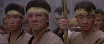 Movie still from “Big Trouble in Little China” (1986), directed by John Carpenter – A group of men standing next to each other; Close Up shot, Low angle