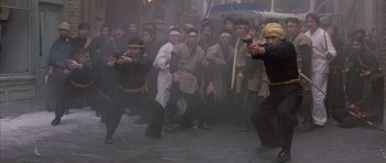 Movie still from “Big Trouble in Little China” (1986), directed by John Carpenter – A group of people in costumes are posing for a picture; Wide shot, High angle
