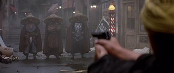 Movie still from “Big Trouble in Little China” (1986), directed by John Carpenter – A man taking a picture of a group of people in costume; Wide shot, Low angle