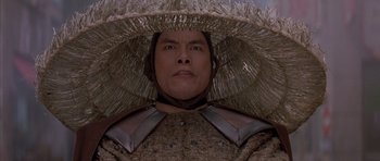 Movie still from “Big Trouble in Little China” (1986), directed by John Carpenter – A man wearing a straw hat and armor; Close Up shot, Low angle
