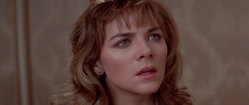 Movie still from “Big Trouble in Little China” (1986), directed by John Carpenter – A woman's face in a room; Close Up shot, Over the shoulder angle