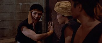 Movie still from “Big Trouble in Little China” (1986), directed by John Carpenter – A man and a woman are fighting in the street; Medium shot, Over the shoulder angle