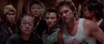 Movie still from “Big Trouble in Little China” (1986), directed by John Carpenter – A group of men standing next to each other; Close Up shot, Low angle