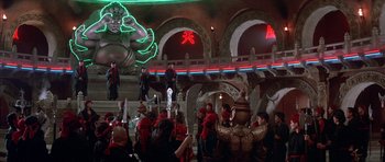 Movie still from “Big Trouble in Little China” (1986), directed by John Carpenter – A group of people standing in front of a building with neon lights; Extreme Wide shot, Low angle