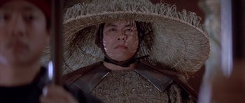Movie still from “Big Trouble in Little China” (1986), directed by John Carpenter – A man wearing a straw hat and a leather jacket; Close Up shot, Low angle