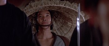 Movie still from “Big Trouble in Little China” (1986), directed by John Carpenter – A man wearing a large straw hat; Close Up shot, Low angle