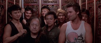 Movie still from “Big Trouble in Little China” (1986), directed by John Carpenter – A group of men standing next to each other; Medium shot, Low angle