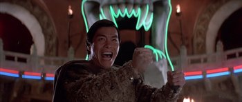 Movie still from “Big Trouble in Little China” (1986), directed by John Carpenter – A man in a brown jacket is laughing; Medium shot, Low angle