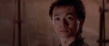 Movie still from “Big Trouble in Little China” (1986), directed by John Carpenter – A person wearing a black shirt; Close Up shot, Low angle