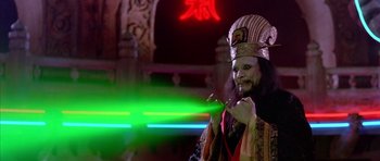 Movie still from “Big Trouble in Little China” (1986), directed by John Carpenter – A man with a beard and a mask is holding a toothbrush; Medium shot, Low angle