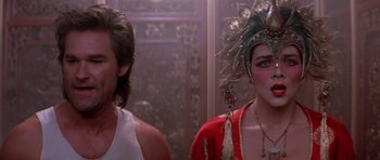Movie still from “Big Trouble in Little China” (1986), directed by John Carpenter – Two women in costumes are standing next to each other; Close Up shot, Over the shoulder angle