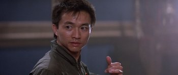 Movie still from “Big Trouble in Little China” (1986), directed by John Carpenter – A person with a hand gesture; Close Up shot, Low angle