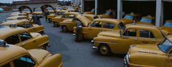 Movie still from “Bigger Than Life” (1956), directed by Nicholas Ray – A row of yellow taxis parked on the side of the street; Extreme Wide shot, High angle