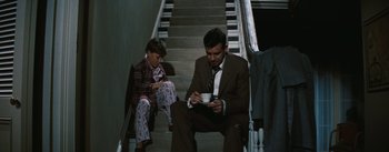 Movie still from “Bigger Than Life” (1956), directed by Nicholas Ray – A man and a boy sitting on some stairs; Medium shot, High angle