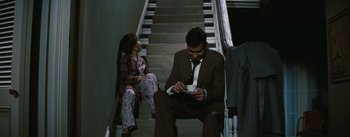 Movie still from “Bigger Than Life” (1956), directed by Nicholas Ray – A man and a girl sitting on the stairs; Wide shot, High angle