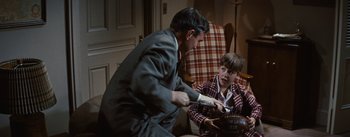 Movie still from “Bigger Than Life” (1956), directed by Nicholas Ray – A man and a young boy in a living room; Medium shot, Over the shoulder angle