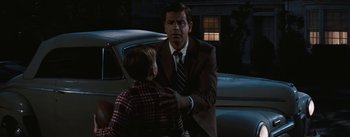 Movie still from “Bigger Than Life” (1956), directed by Nicholas Ray – A man in a suit and tie standing next to a young boy; Medium shot, Over the shoulder angle