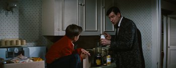Movie still from “Bigger Than Life” (1956), directed by Nicholas Ray – A man and two boys in a kitchen with a blender; Medium shot, Over the shoulder angle