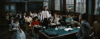 Movie still from “Bigger Than Life” (1956), directed by Nicholas Ray – A group of people sitting at desks in a classroom; Wide shot, High angle
