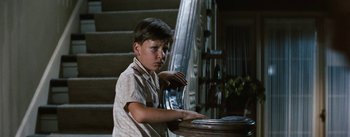 Movie still from “Bigger Than Life” (1956), directed by Nicholas Ray – A young boy sitting in front of a piano; Medium shot, Low angle