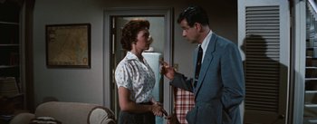 Movie still from “Bigger Than Life” (1956), directed by Nicholas Ray – A man and a woman are talking in a living room; Medium shot, Over the shoulder angle