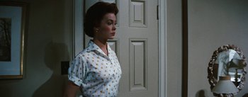 Movie still from “Bigger Than Life” (1956), directed by Nicholas Ray – A woman standing in front of a white door; Medium shot, Low angle