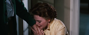 Movie still from “Bigger Than Life” (1956), directed by Nicholas Ray – A person touching a woman's face; Close Up shot, Over the shoulder angle
