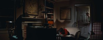 Movie still from “Bigger Than Life” (1956), directed by Nicholas Ray – A person sitting on a chair in a room; Wide shot, High angle