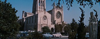 Movie still from “Bigger Than Life” (1956), directed by Nicholas Ray – An old photo of a church with cars parked in front of it; Extreme Wide shot, Low angle