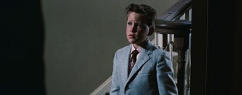 Movie still from “Bigger Than Life” (1956), directed by Nicholas Ray – A boy in a suit and tie standing on a staircase; Medium shot, Low angle