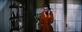 Movie still from “Bigger Than Life” (1956), directed by Nicholas Ray – A woman talking on a phone while standing next to a window; Medium shot, Low angle