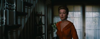 Movie still from “Bigger Than Life” (1956), directed by Nicholas Ray – A woman in a red dress standing next to a window; Medium shot, Low angle