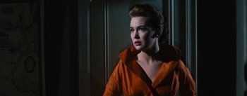 Movie still from “Bigger Than Life” (1956), directed by Nicholas Ray – A woman in an orange jacket looking to her left; Close Up shot, Low angle