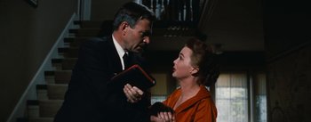 Movie still from “Bigger Than Life” (1956), directed by Nicholas Ray – A man and a woman are holding a book together; Medium shot, Low angle