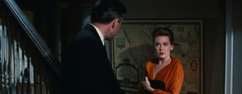 Movie still from “Bigger Than Life” (1956), directed by Nicholas Ray – A man and a woman are standing in front of a map; Medium shot, Over the shoulder angle